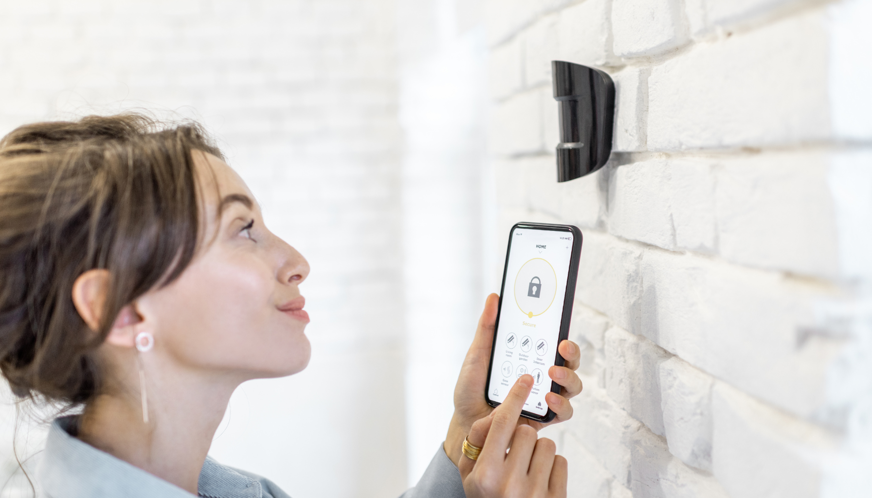 femme devant un detecteur de mouvement lier à une application de système de sécurité